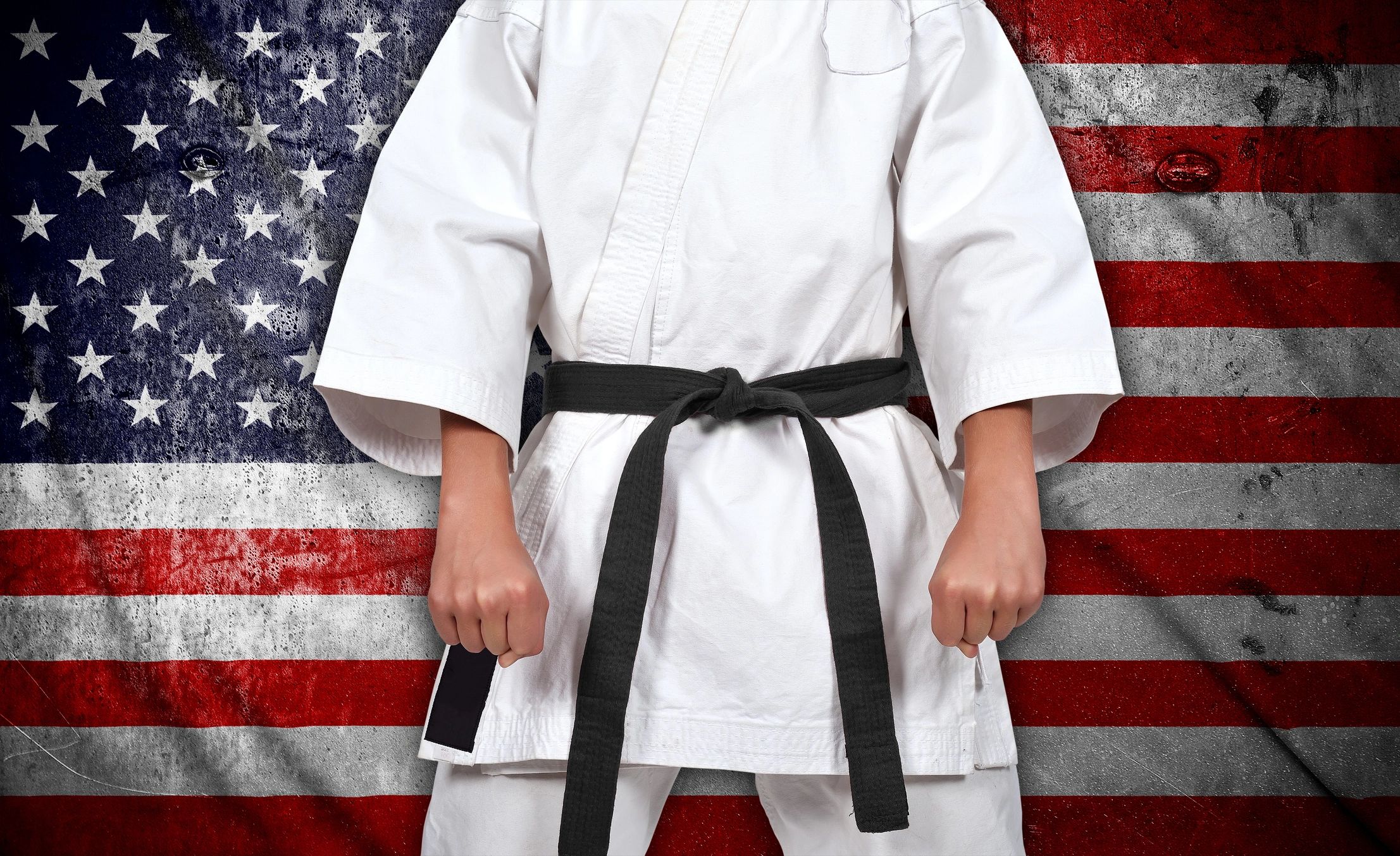 Karate boy in kimono on american flag background